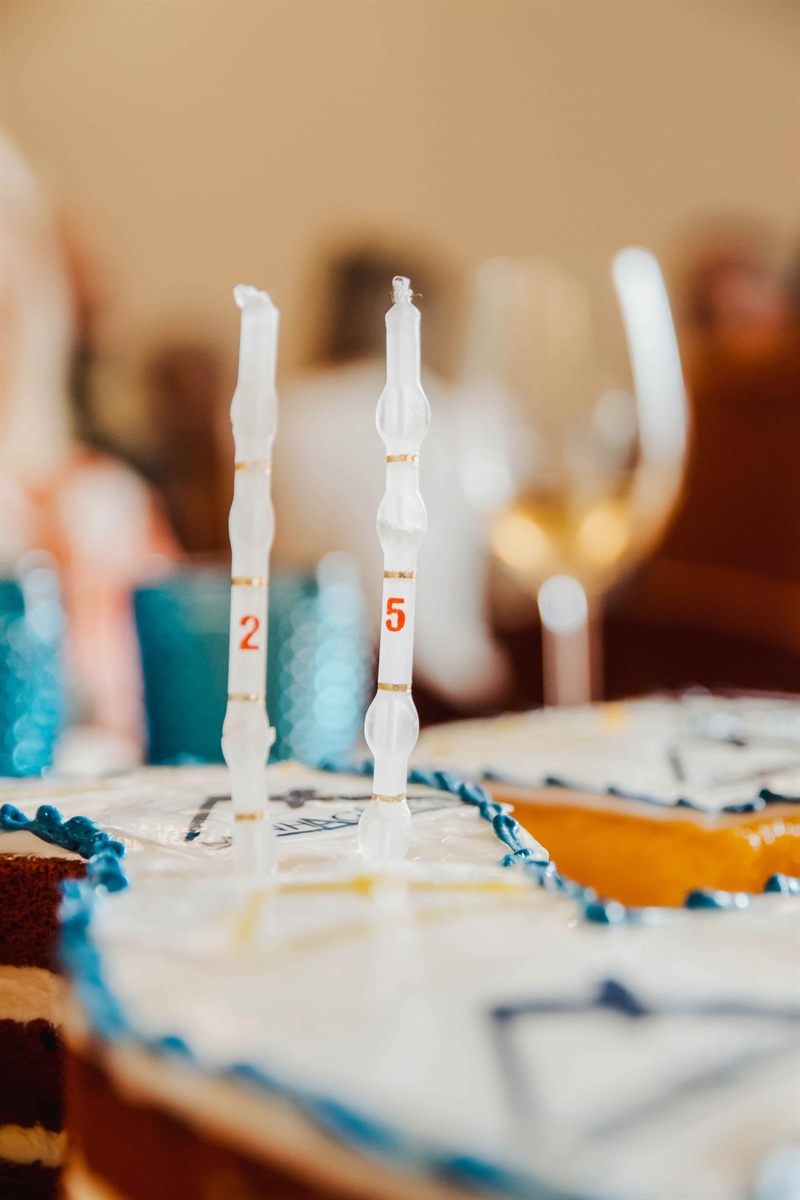 Velas com os números dois e cinco no bolo de aniversário.